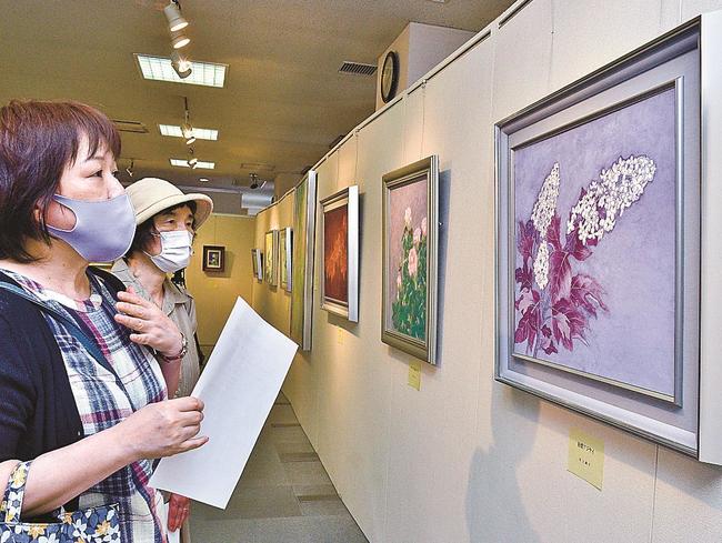 岩絵の具で描かれた作品を鑑賞する人たち