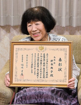 表彰状を手に活動を振り返る枡本典子部長＝益田市常盤町、市役所