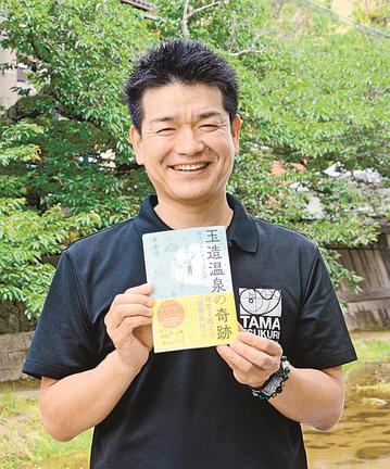 書籍「玉造温泉の奇跡　観光ブランディング入門」を手にする角幸治さん＝松江市玉湯町玉造