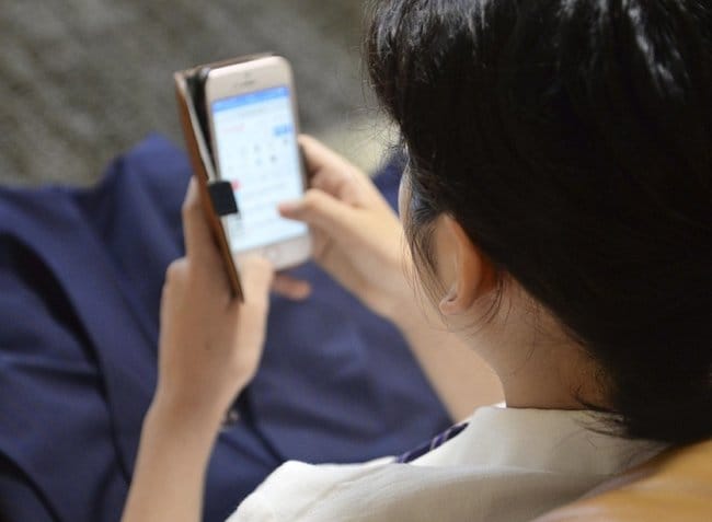 スマートフォンを見る中学生。愛知県豊明市はスマホ使用時間の制限を呼びかける条例案を提出した