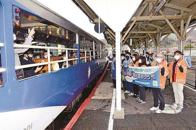 小雨が降る中、おろち号を見送る雲南市職員ら＝雲南市木次町里方、ＪＲ木次駅