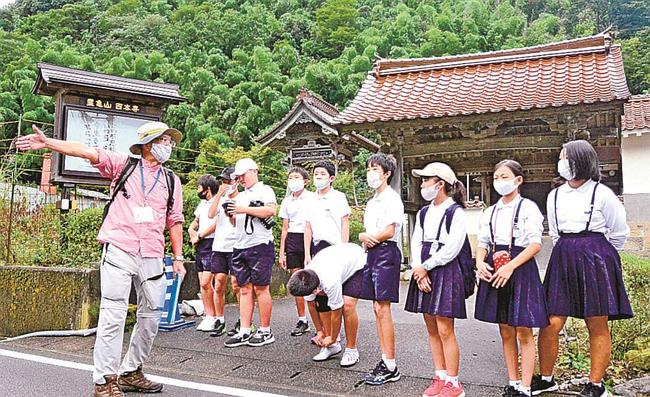 益田市内の小学生に解説するガイド（左端）＝大田市大森町、石見銀山遺跡（２０２０年９月）