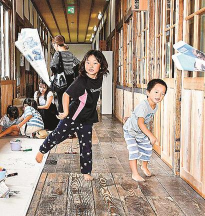 廊下で紙飛行機を投げ合う子どもたち＝出雲市斐川町、斐川環境学習センター