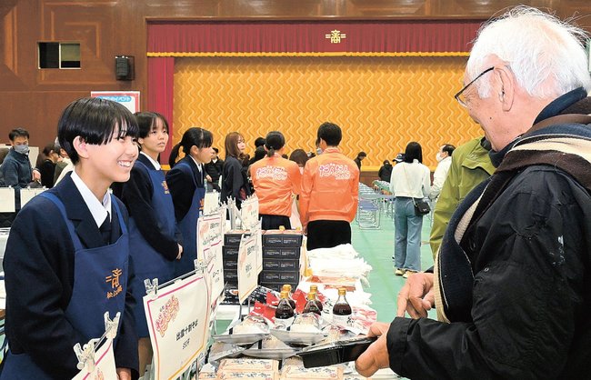 笑顔で接客し、地元の名産品を販売する松江商業高校の生徒（左）＝松江市浜乃木８丁目