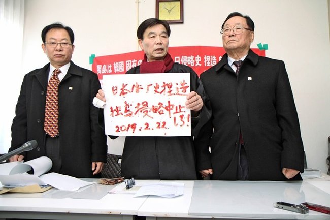 記者会見で血判状を見せる独島守護全国連帯の崔在翼議長（中央）＝２０１９年２月２２日、松江市内