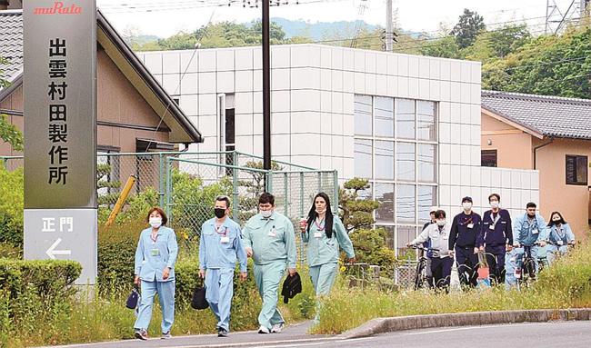 制服姿の従業員が列をつくる出雲村田製作所の朝の通勤風景＝出雲市斐川町上直江