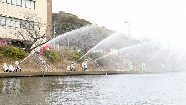 一斉放水する消防団員＝浜田市殿町、市役所裏浜田川