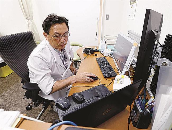 自宅療養中の新型コロナ患者をオンラインで診療する「山下診療所大塚」の山下巌院長＝２７日、東京都豊島区