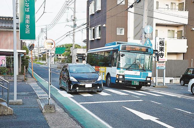 Ａランクのバス停に停車したバスを追い越す乗用車＝鳥取市布勢