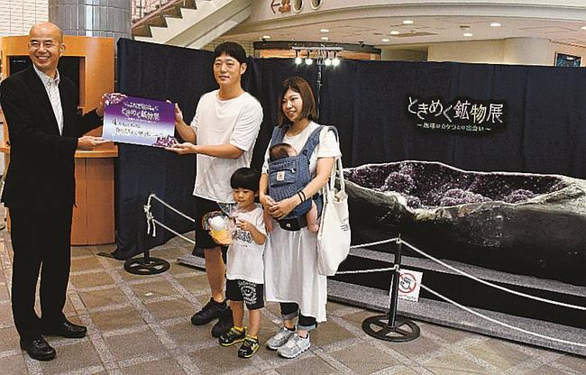 来場４万人の記念品を受け取る朝倉さん一家＝大田市三瓶町、島根県立三瓶自然館サヒメル