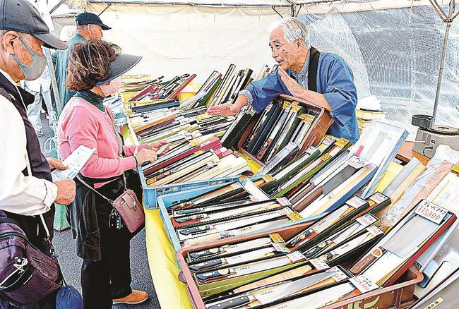 刃物業者の説明を聞きながら品定めをする来場者＝安来市安来町、和鋼博物館