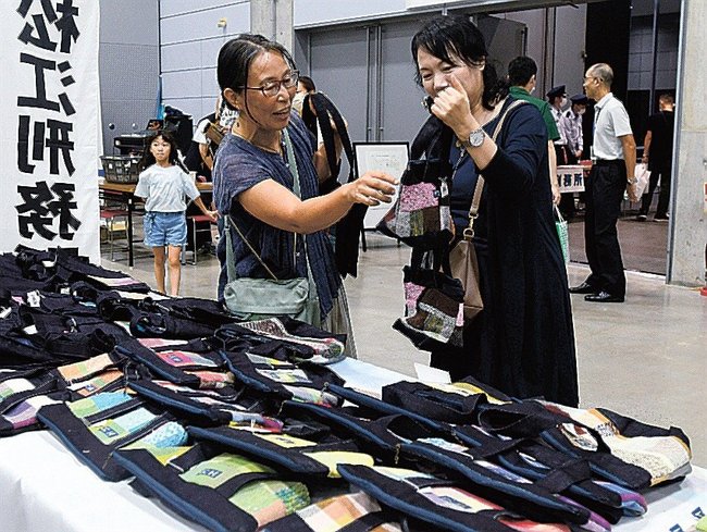受刑者が丁寧に作ったかばんを選ぶ来場者=松江市学園南1丁目、くにびきメッセ