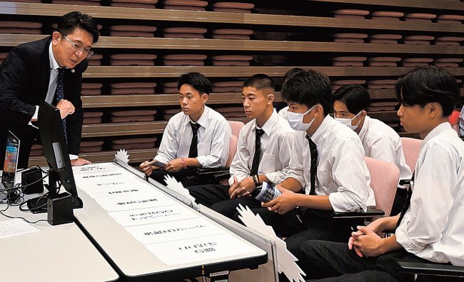 企業の担当者(左端)から説明を聞く高校生=浜田市野原町、島根県立大浜田キャンパス