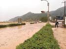 稲佐川が氾濫し、浸水した道路＝８日午前９時１８分、出雲市大社町杵築北