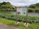 佐太講武貝塚の説明板。川の向こうが鹿島中学校＝松江市鹿島町佐陀宮内
