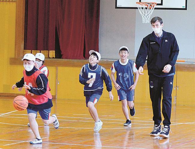 ニック・ケイ選手（右）とバスケットボールを楽しむ児童＝松江市古曽志町、古江小学校
