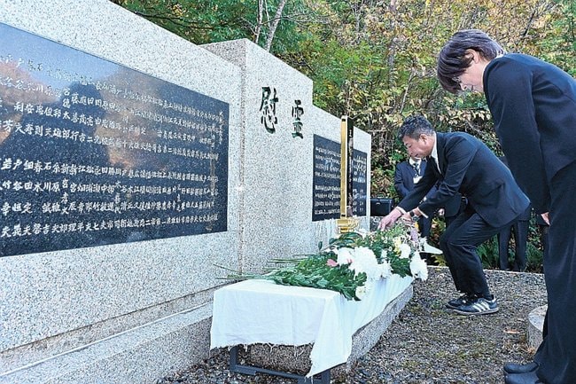 追悼の集いで慰霊碑に献花する参列者=松江市玉湯町玉造、玉造ふれあい公園