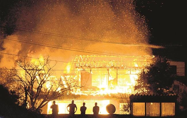 火の粉を上げて燃える民家＝１１日午後６時３６分、雲南市加茂町神原