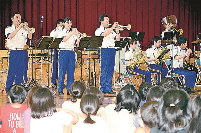 児童を前に、軽快な吹奏楽を披露する島根県警察音楽隊の隊員たち＝出雲市西平田町、平田小学校〓（?）