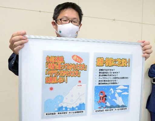 雪山登山の注意点を記したポスターを紹介する谷口善正巡査部長＝鳥取県八頭町郡家、郡家署