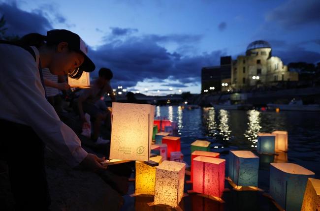 原爆ドーム前の元安川に灯籠を流す女の子＝２０２３年８月６日夜、広島市