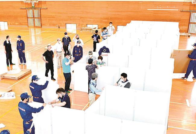 避難所でのコロナ感染防止を目的に、間仕切りの組み立てを訓練する参加者＝江津市桜江町川戸、桜江中学校