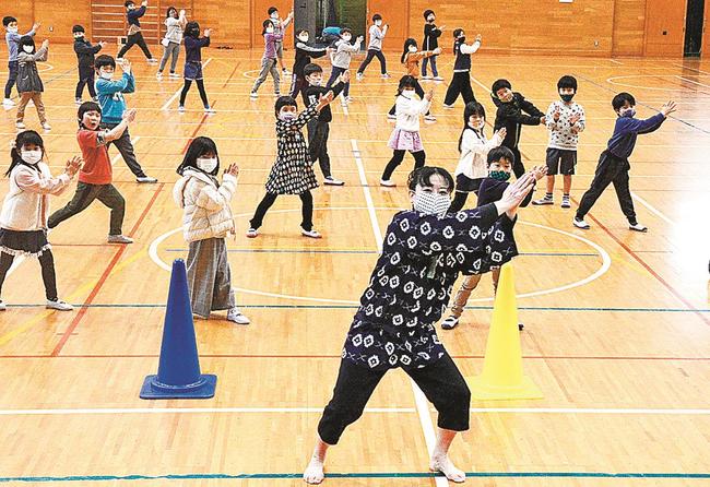 野島優子さん（中央）と「どじょうすくいパラパラ」を踊る八雲小１年生たち〓（?）松江市八雲町西岩坂