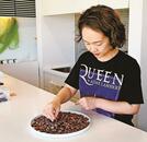 カカオ豆を選別する西森亜矢店長。輸送コストの低い東南アジア産の輸入を検討している＝出雲市斐川町坂田、ラ・ショコラトリ・ナナイロ