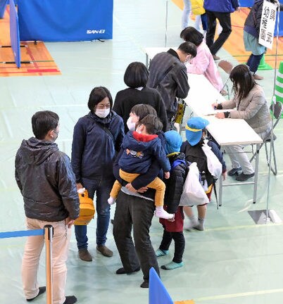 子どもを保護者に引き渡す手順を訓練する関係者＝松江市学園南１丁目、市総合体育館