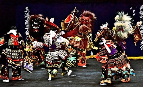 豪華な衣装、個性的な面をつけて舞う益田市内の神楽社中（資料）