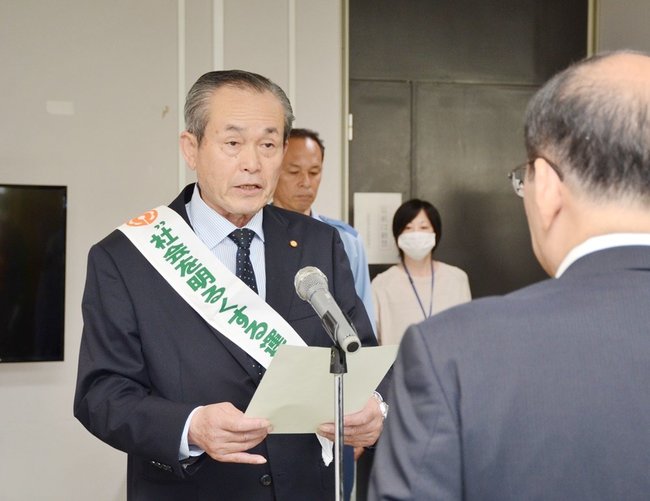首相メッセージを読み上げる竹山勝彦会長＝浜田市殿町、市役所
