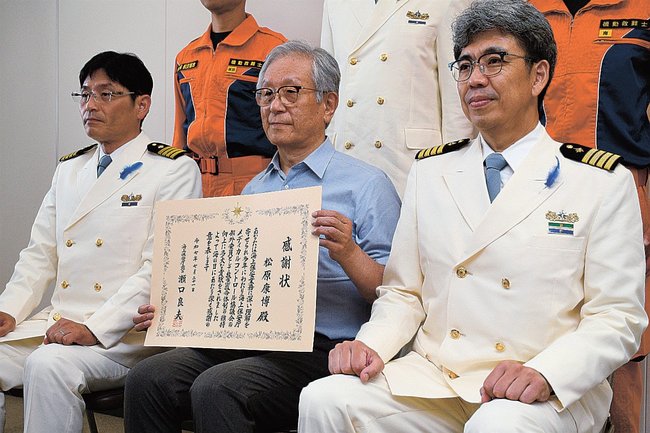 海上保安庁表彰を受けた松原康博さん（中央）＝境港市佐斐神町、美保航空基地