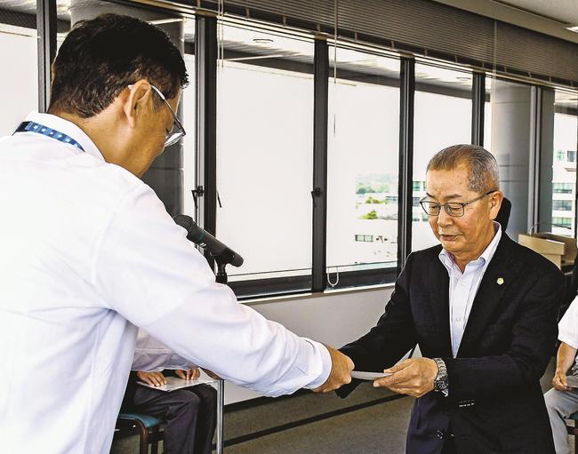 贈呈書を受け取る安来市少年補導委員連絡会の山本芳郎会長（右）＝松江市殿町、島根県市町村振興センター