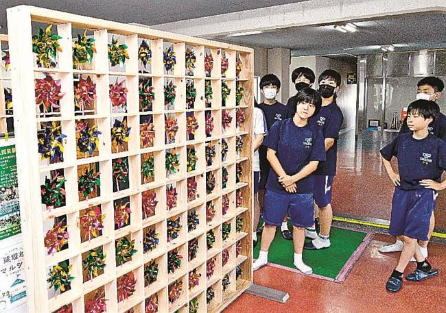 木枠に設置した風車の出来栄えを確かめる高津中の生徒=益田市高津1丁目、高津小学校