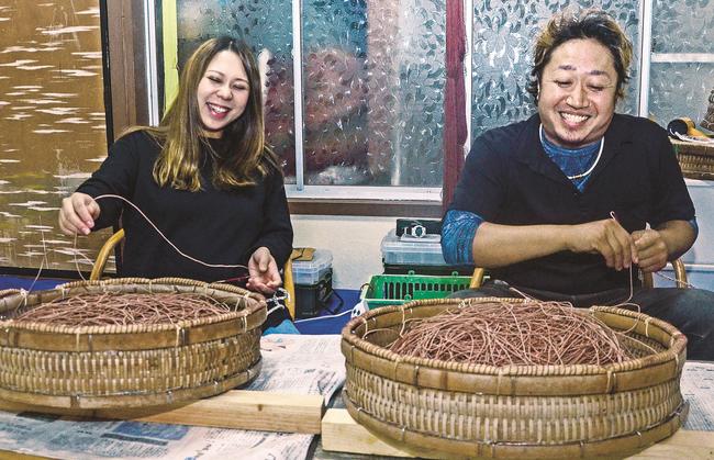はえ縄漁の仕掛けを作る夫の東雄大さん（右）と妻の瑞穂さん＝出雲市小伊津町