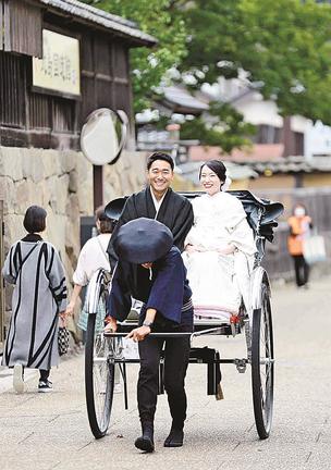 人力車に乗って結婚式場に向かう岡隼斗さん（左）と翔子さん＝出雲市大社町杵築東