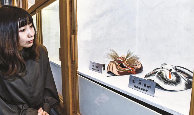 大元神楽の社中・団体に継承される面の複製を鑑賞する来館者＝江津市江津町、市総合市民センター