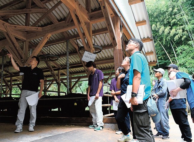 岡田佑真専務（左）から説明を受ける学生ら＝雲南市大東町下佐世、熟豊ファーム