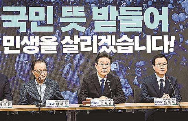 韓国総選挙での勝利を受け発言する、野党「共に民主党」の李在明代表（中央）＝１１日、ソウル（共同）