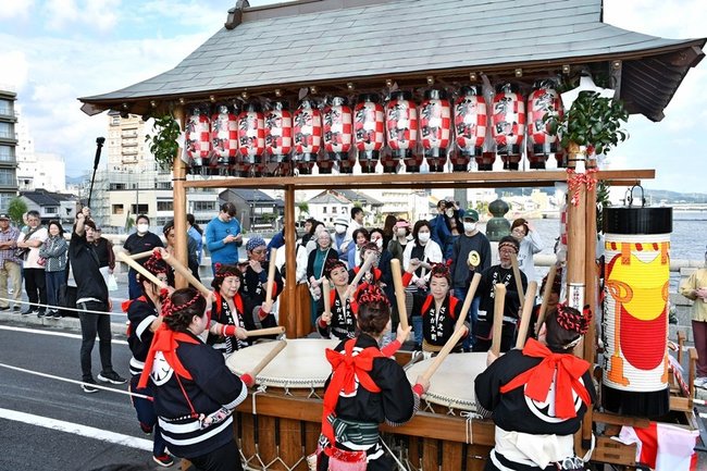 息の合ったばちさばきを見せる、鼕行列の参加者＝松江市、松江大橋