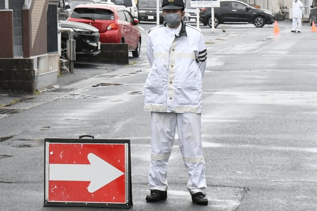強盗事件が発生した現場付近の道路に立つ警察官＝７日午後０時40分ごろ、松江市学園２丁目