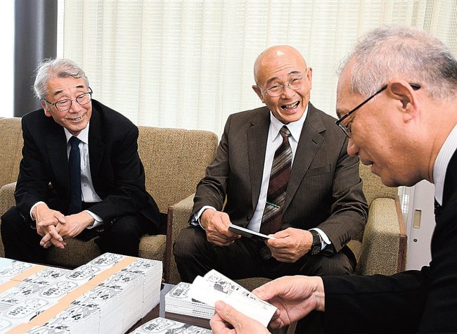 杉谷学教育長(右)に本の内容を紹介する玉田達会長(中央)と宍道年弘事務局長=出雲市今市町、市役所