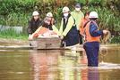 道路が冠水しボートで救助される住民＝１２日午後１時１１分、出雲市所原町