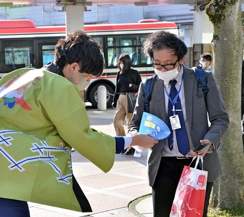 山陰中央新報デジタルのチラシを受け取る市民＝松江市朝日町、松江テルサ前