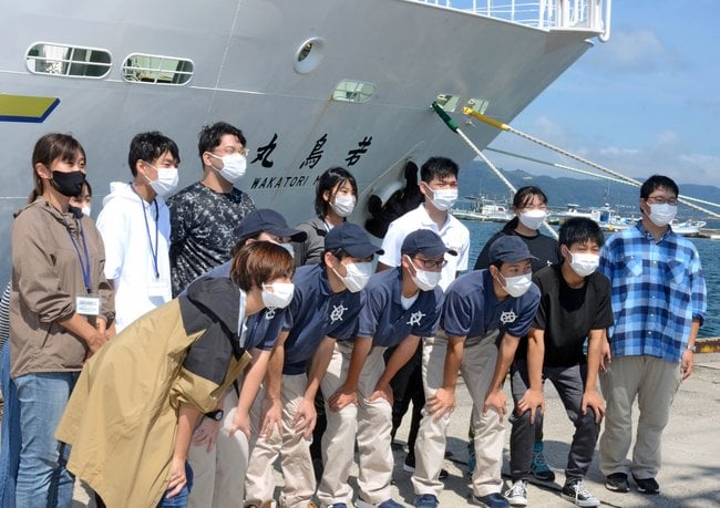 出港を前に記念写真に収まる参加者=境港市竹内団地