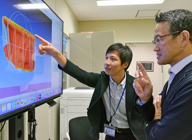 腰骨から年齢を特定する研究について飯野守男教授（右）と議論するダワ・ザンポさん＝米子市西町、鳥取大医学部