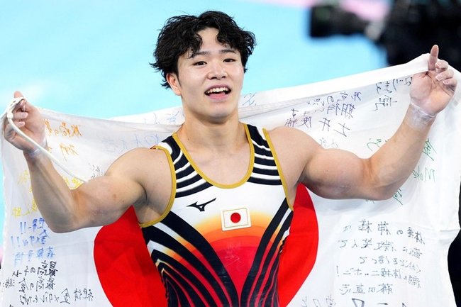 体操男子個人総合で優勝し、日の丸を手に喜ぶ岡慎之助＝パリ（共同）