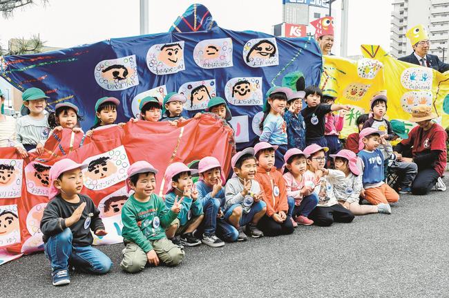 こいのぼりと一緒に記念撮影をする園児と関係者＝出雲市今市町、市役所