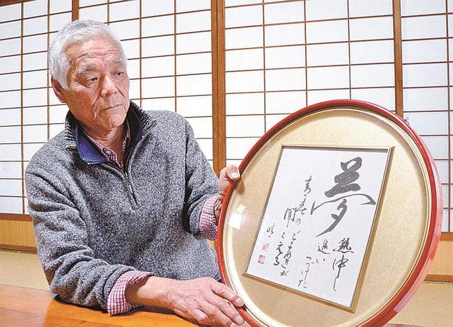 渡辺晴夫さんの書を見て、思いをはせる金津光則さん＝松江市島根町加賀