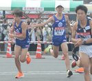 出雲駅伝の１区から２区の中継所で、たすきを受け取って走り出す順大の三浦龍司（左端）‖第１中継所、出雲市役所・ＪＡしまね前